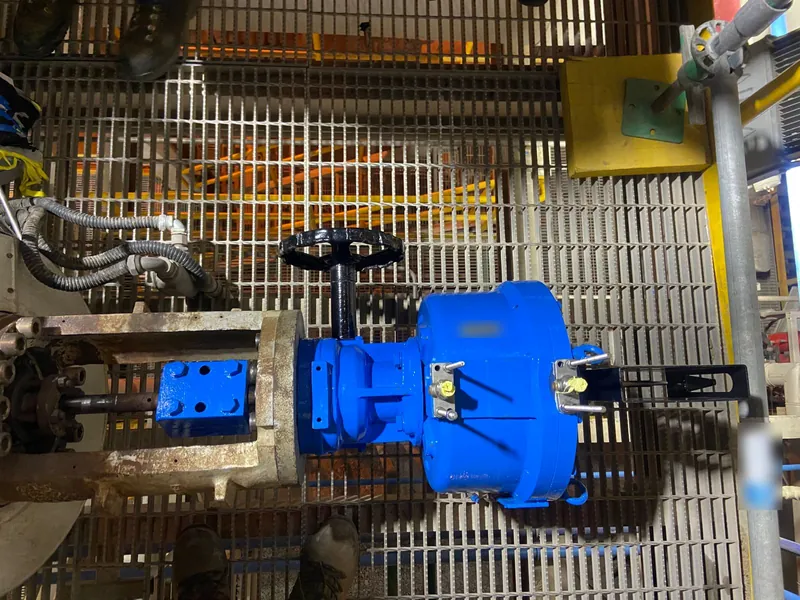 Actuador neumático azul recién reparado y pintado, montado sobre una válvula en una plataforma de planta